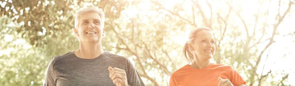 Couple jogging together outdoors showing the active lifestyle and reduced-inflammation benefits of GLP-1 microdosing therapy.